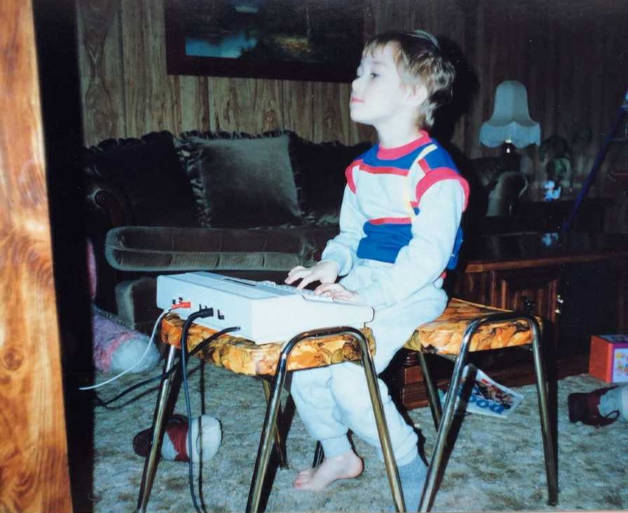 Travis Friesen as a young child exploring an early personal computer